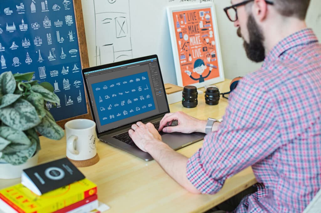 man achter computer in creatieve ruimte met Adobe Illustrator op het scherm. DWM Trainingen.