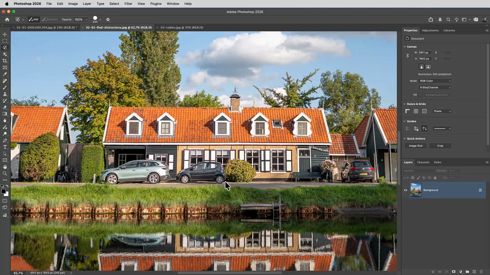Foto van Hollandse huizen aan het water met geparkeerde auto’s en een lantaarnpaal